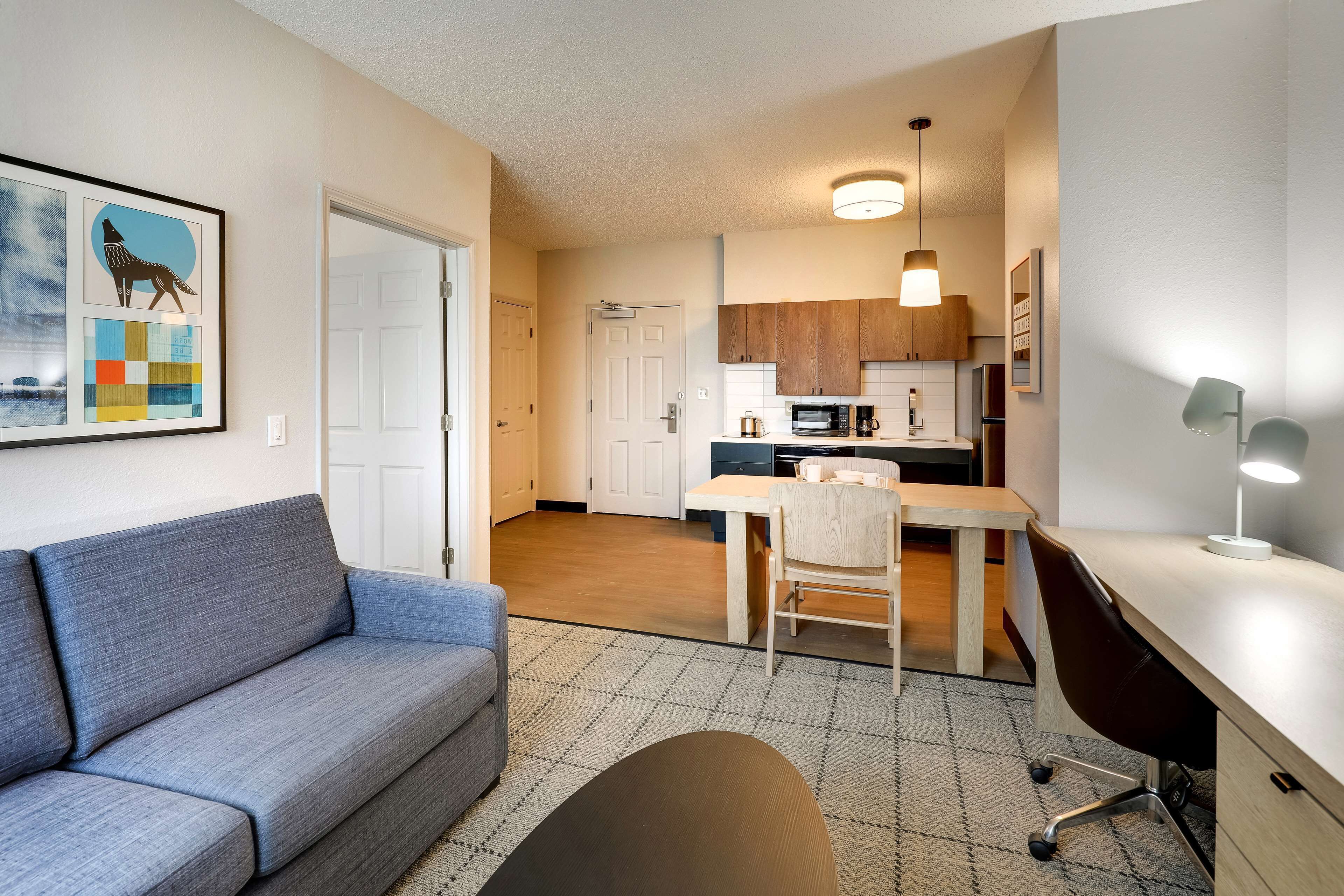 A modern apartment with a living room, kitchenette, and a dining area.