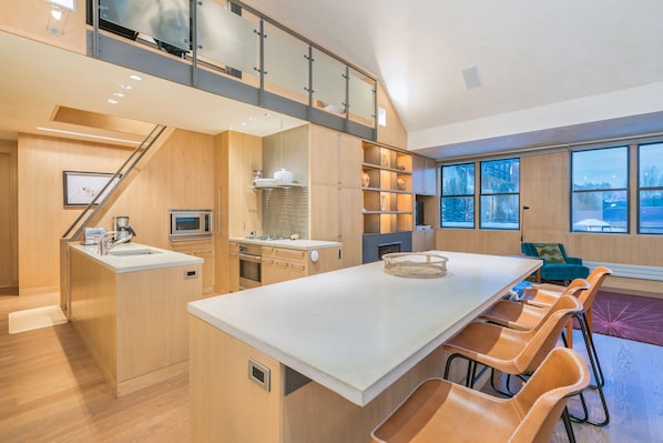Una cocina moderna con una isla central, armarios de madera y un nivel entre piso.