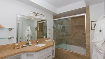 Une salle de bain moderne avec une douche à parois de verre, un meuble-lavabo avec un évier et un miroir, et un porte-serviettes.