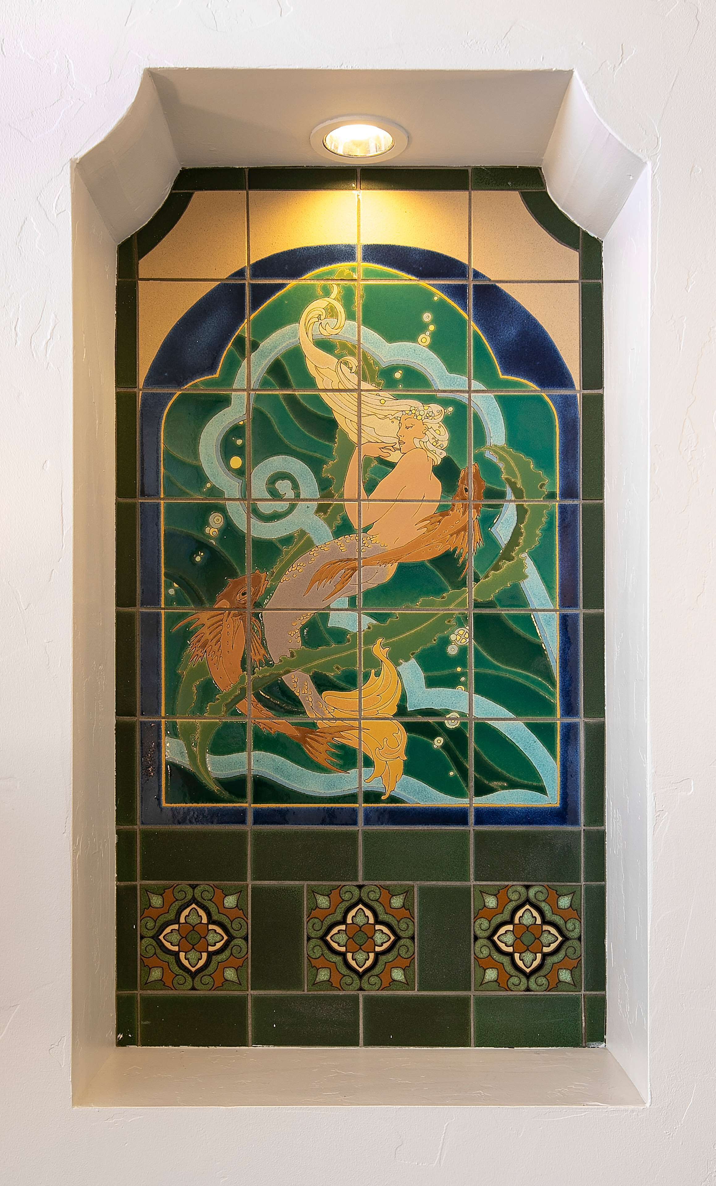A stained glass window with a mermaid and fish design.