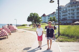 Un paseo marítimo con sillas de playa y un edificio al fondo.