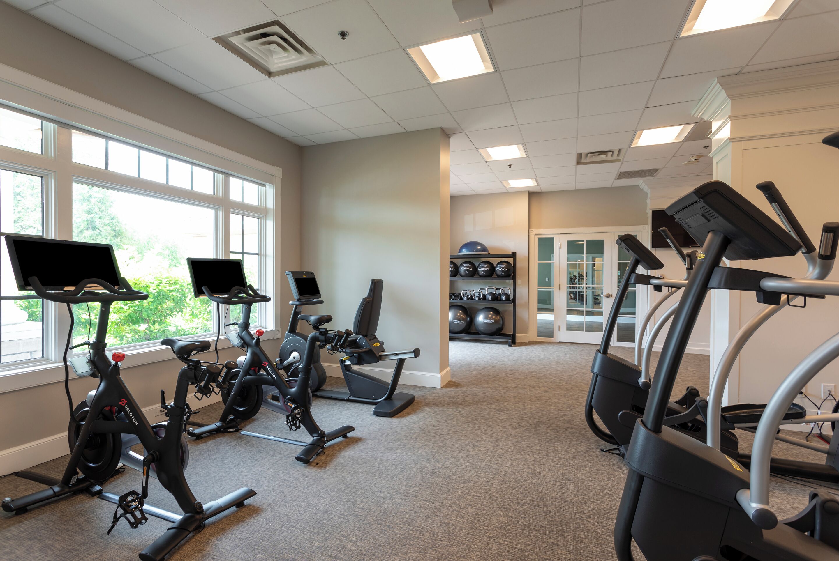 A gym with stationary bikes, treadmills, and exercise balls.