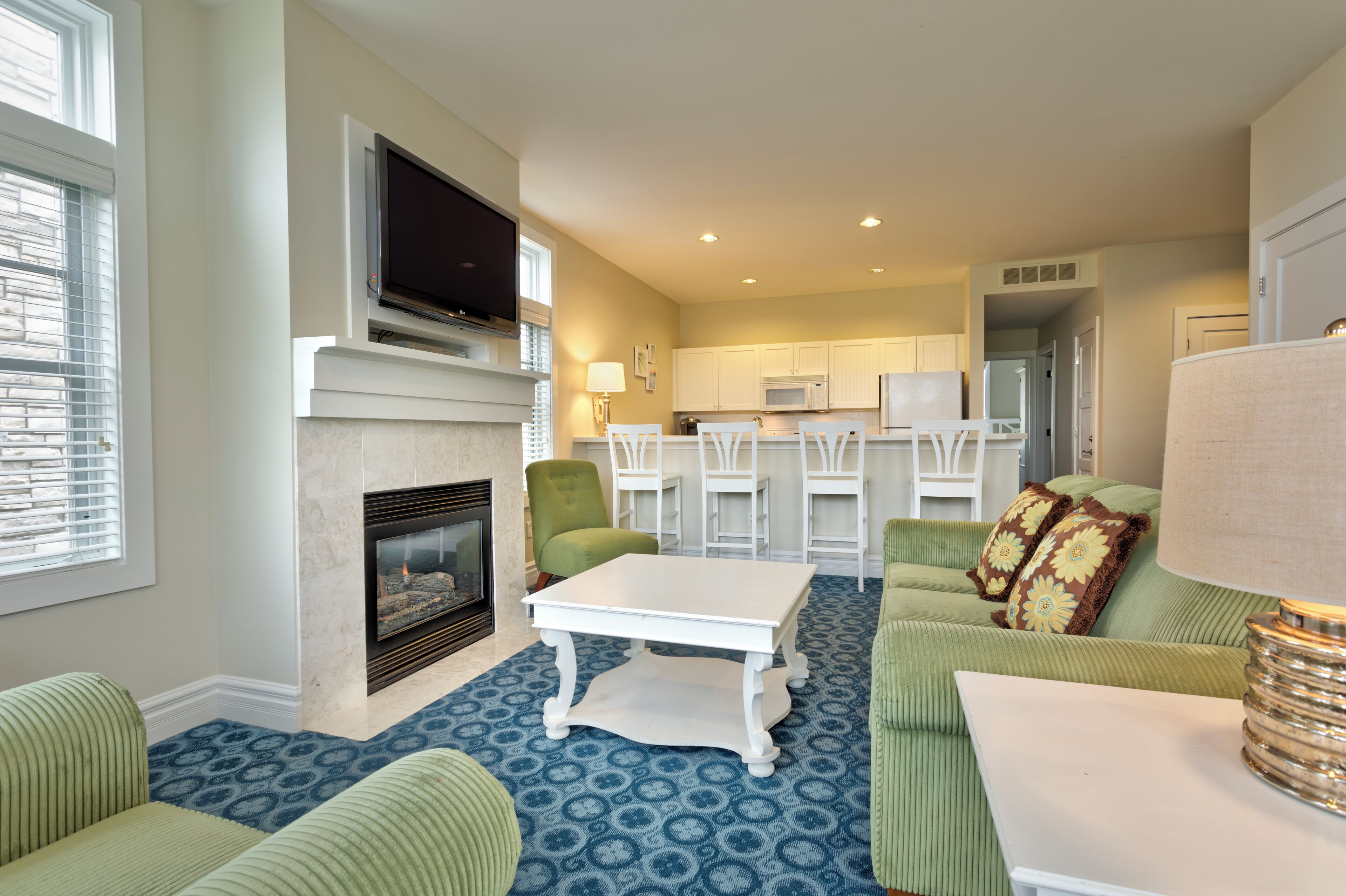 A living room with a fireplace, a television, and a dining area with chairs and a table.