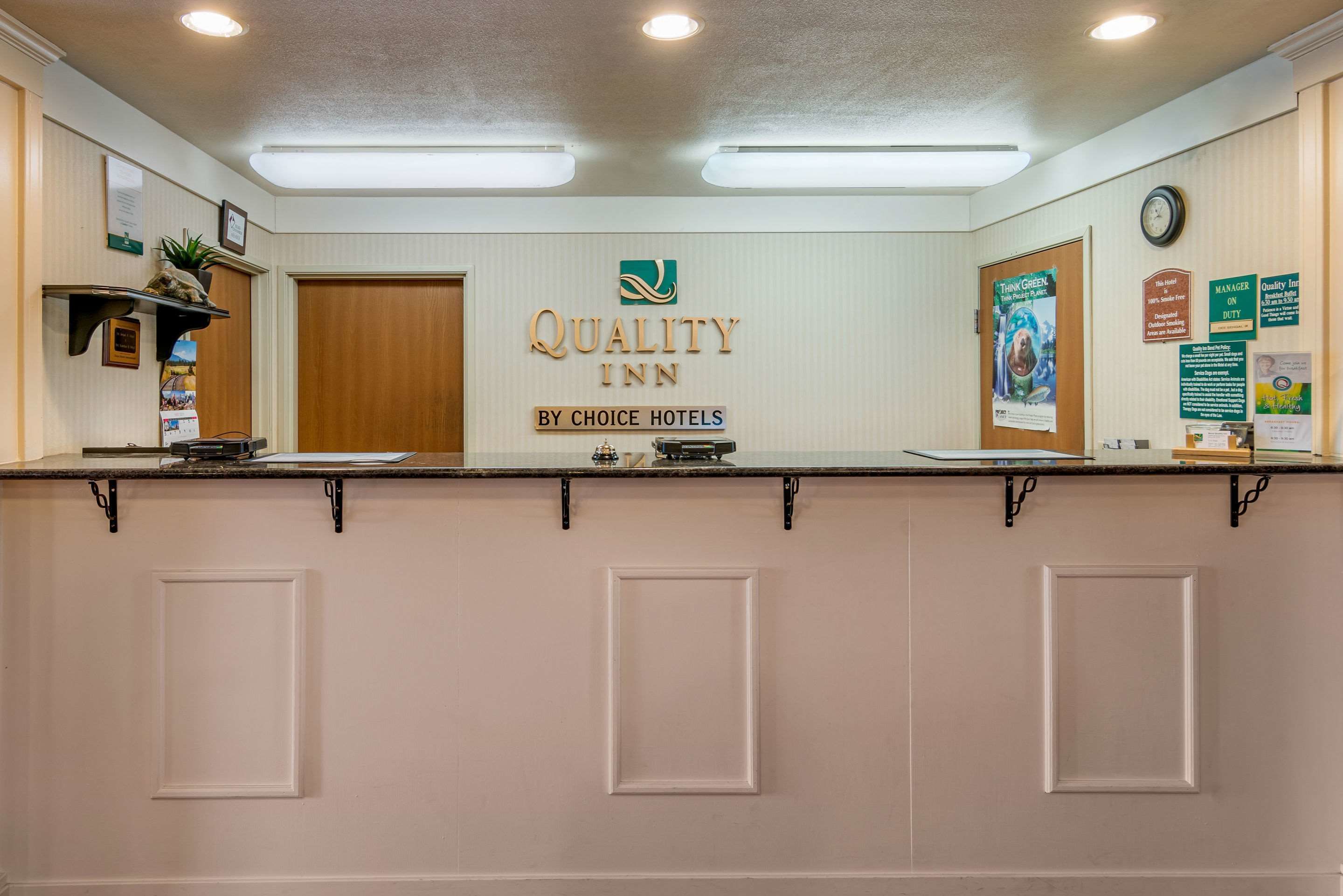 A reception desk with a sign reading "Quality Inn by Choice Hotels".