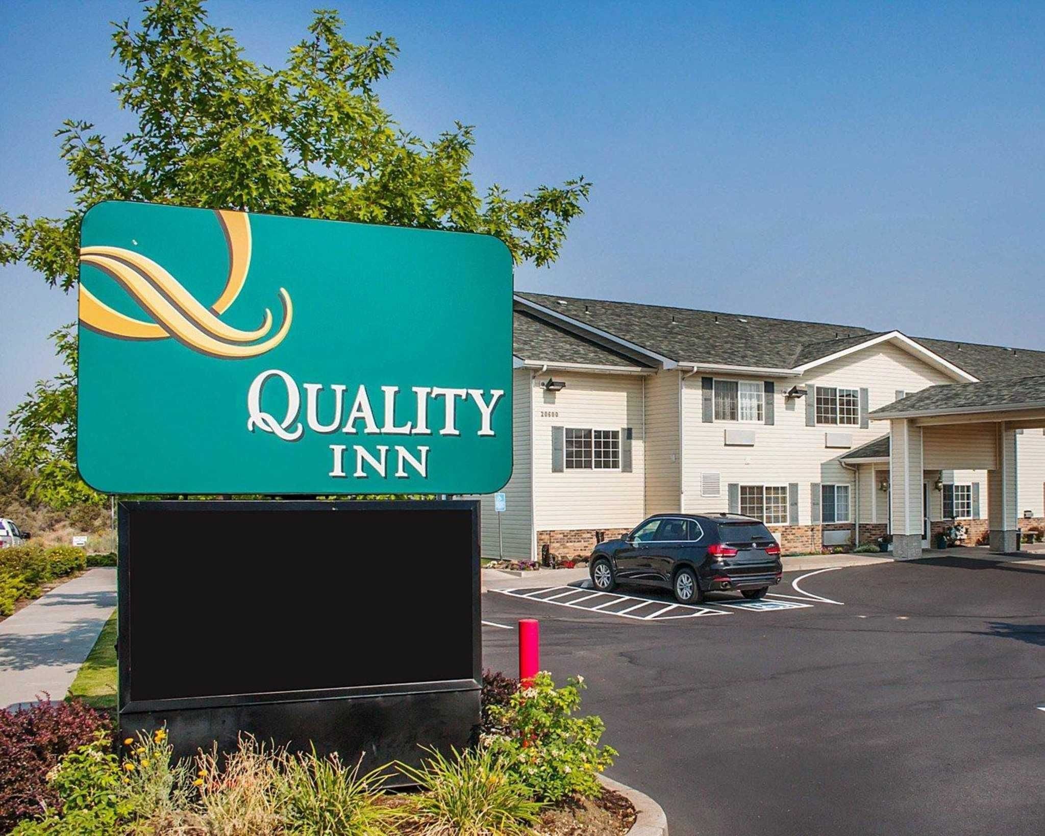 A Quality Inn sign with a building in the background.
