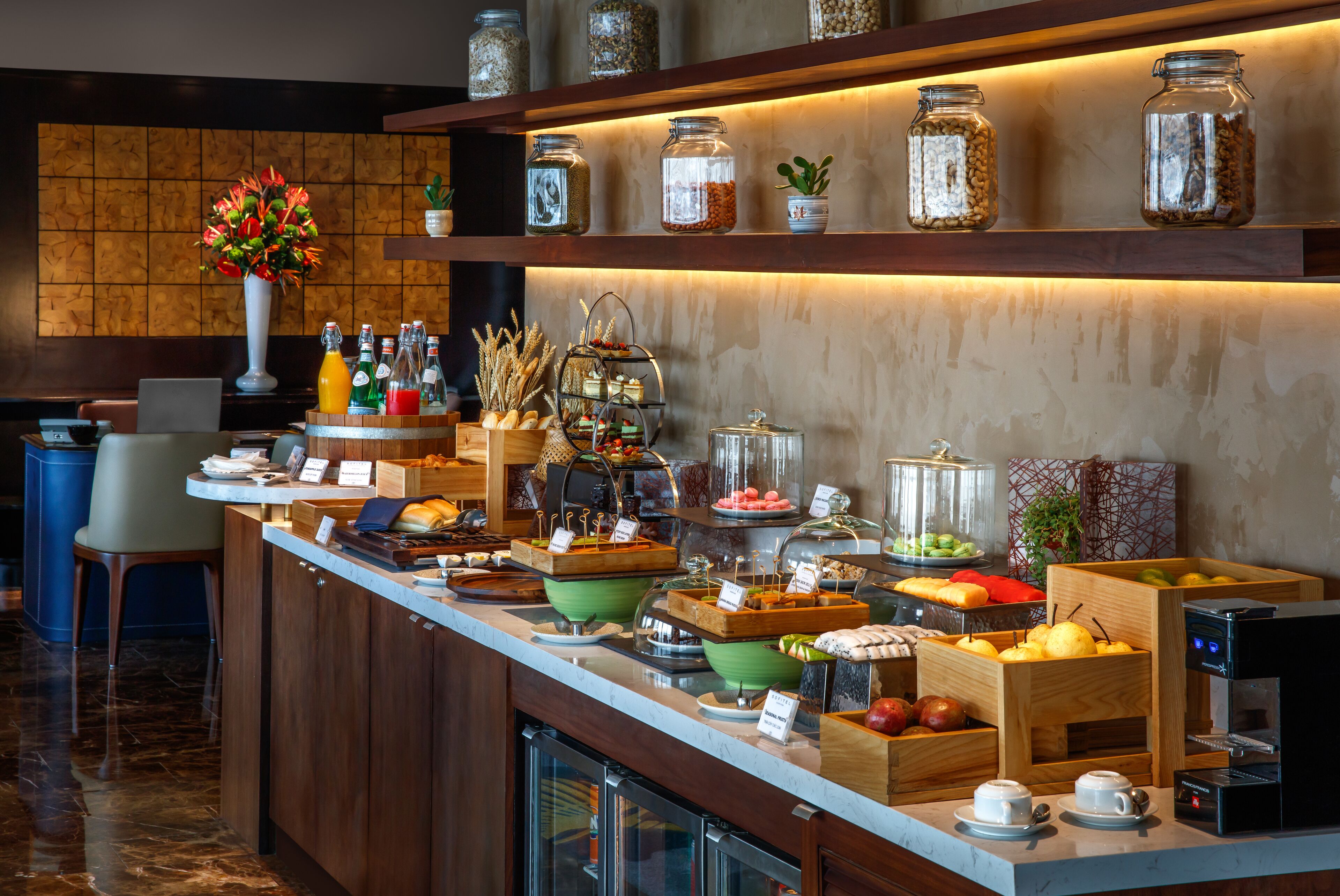A buffet area with various food items, a coffee machine, and decorative jars on shelves.