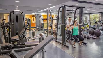A gym with weightlifting equipment, treadmills, and exercise balls.