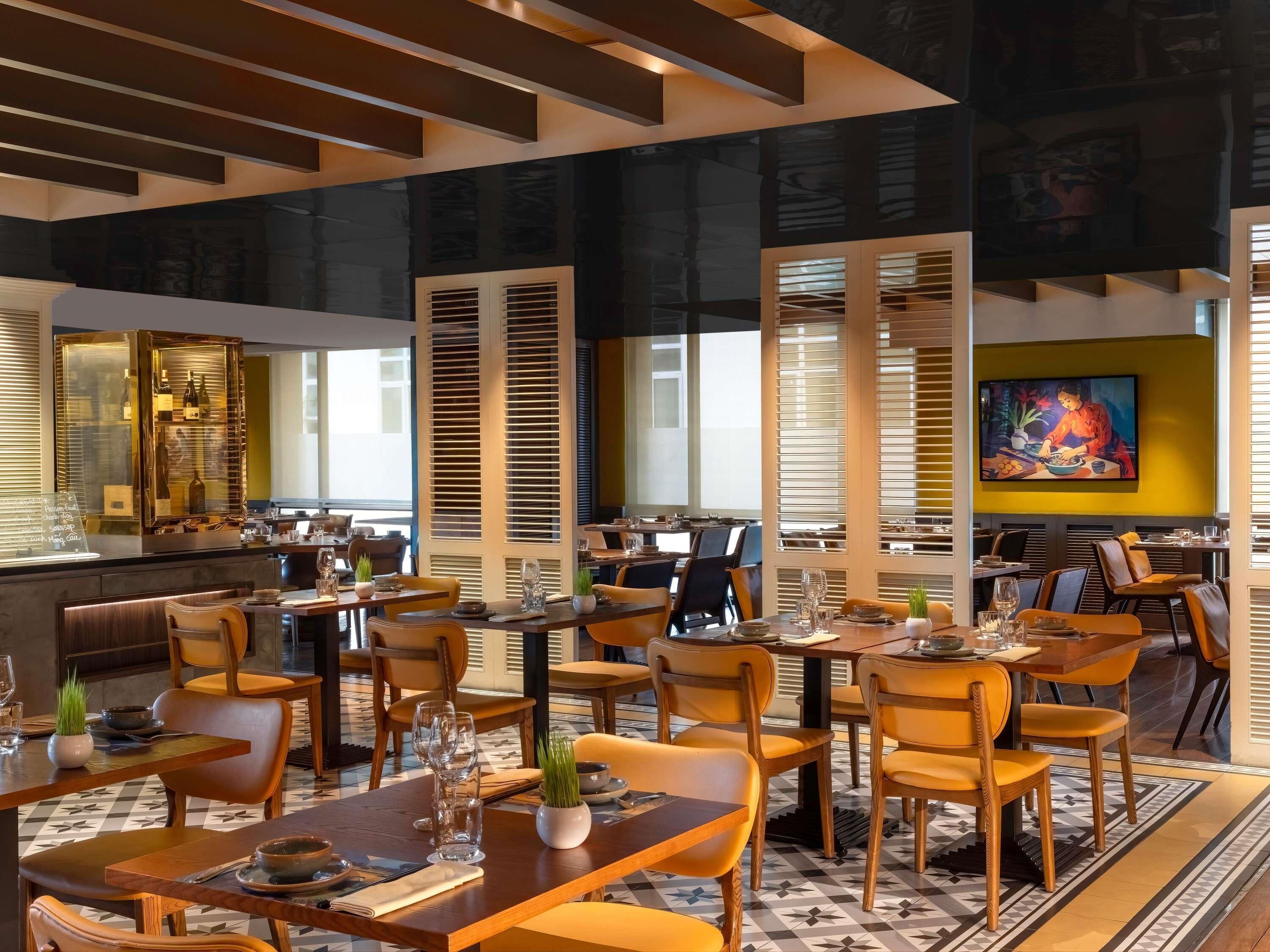 Un restaurant doté de plusieurs tables, de chaises et d’un bar.