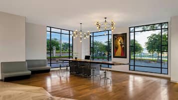 A modern interior with a bar area, seating, and large windows offering views of the outdoors.