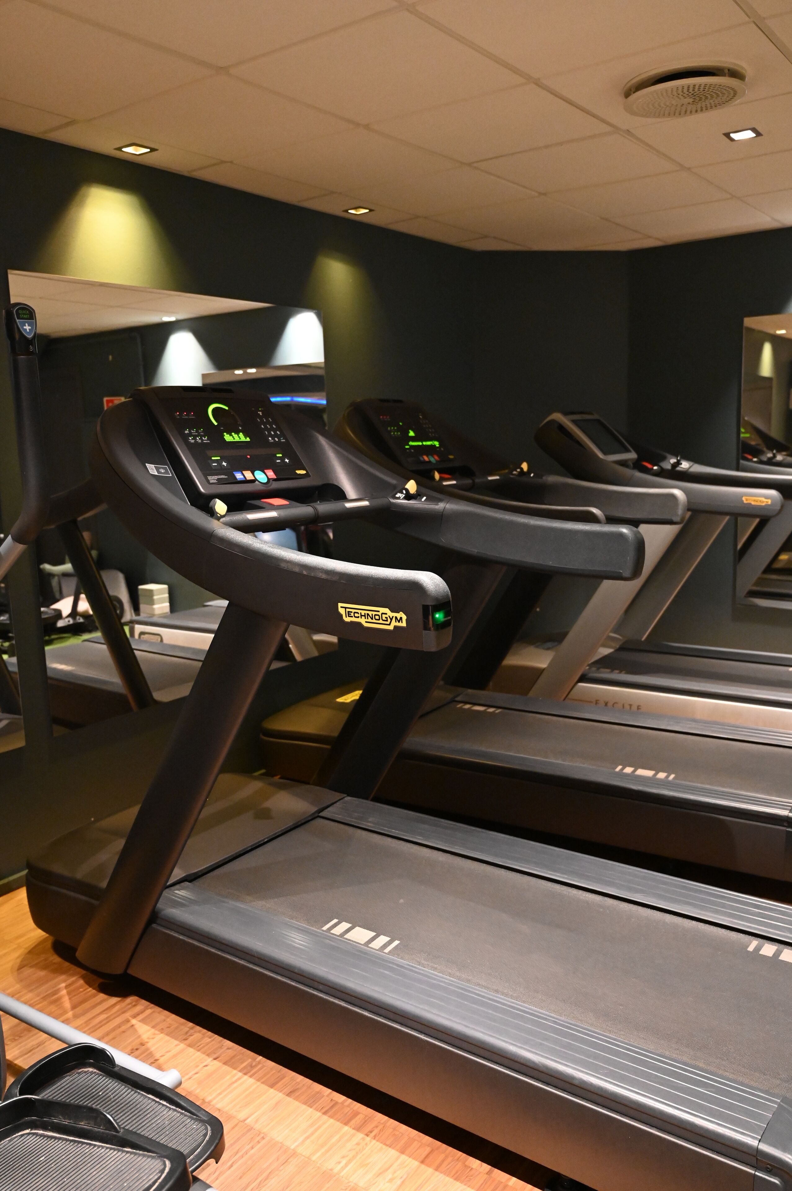 A treadmill with a digital display and a control panel.