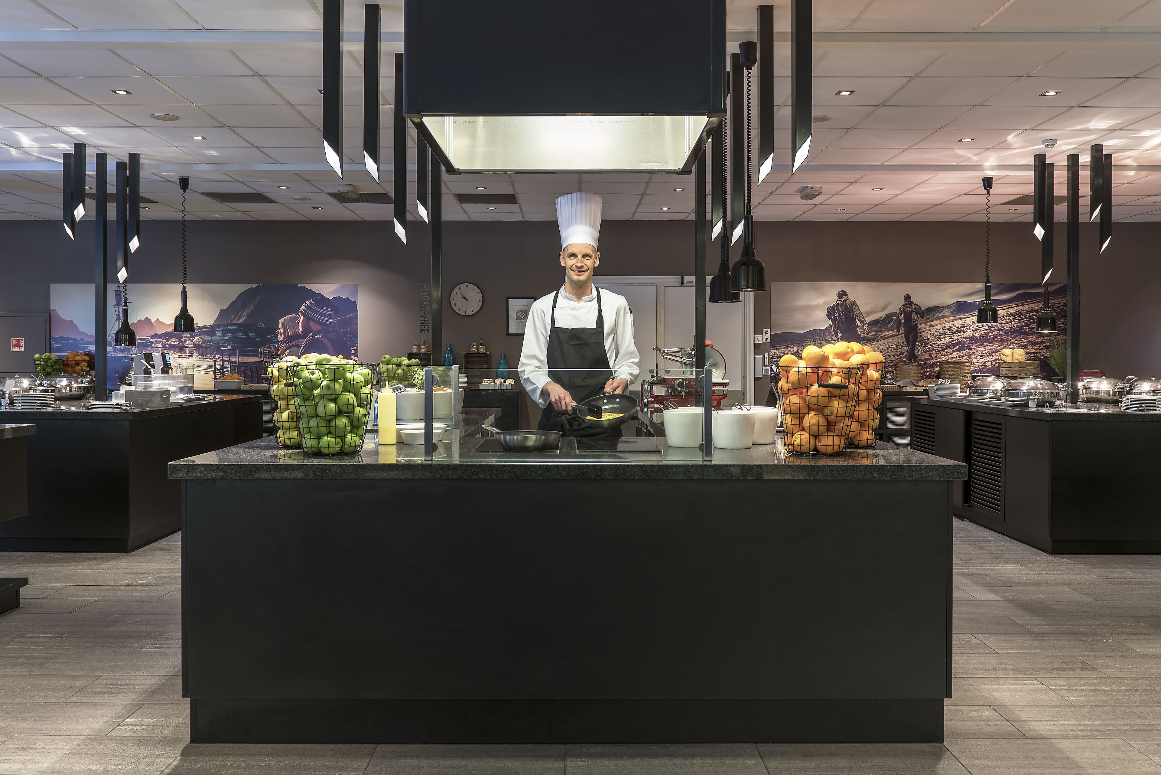 A chef at a modern kitchen counter with fresh produce and cooking utensils.