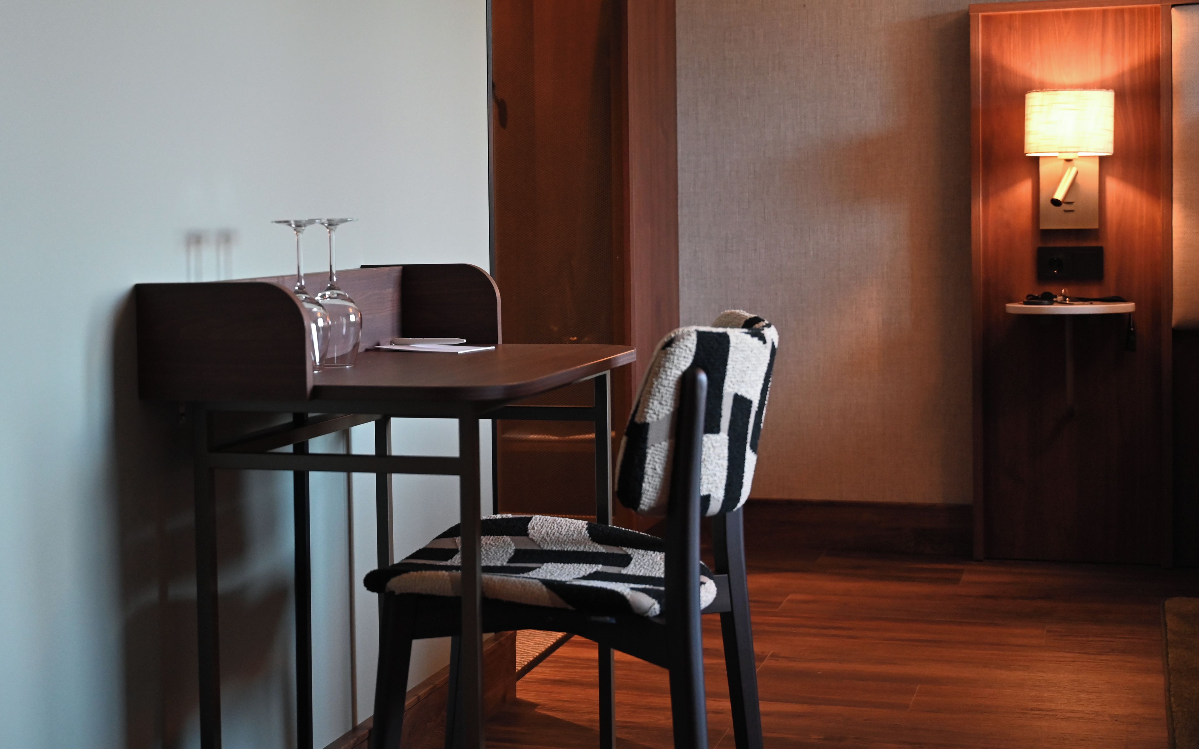 Een eetgedeelte met een tafel, stoelen, een lamp en een klein spoelbakje.