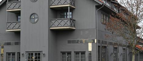 A multi-story building with balconies, large windows, and a flat roof.
