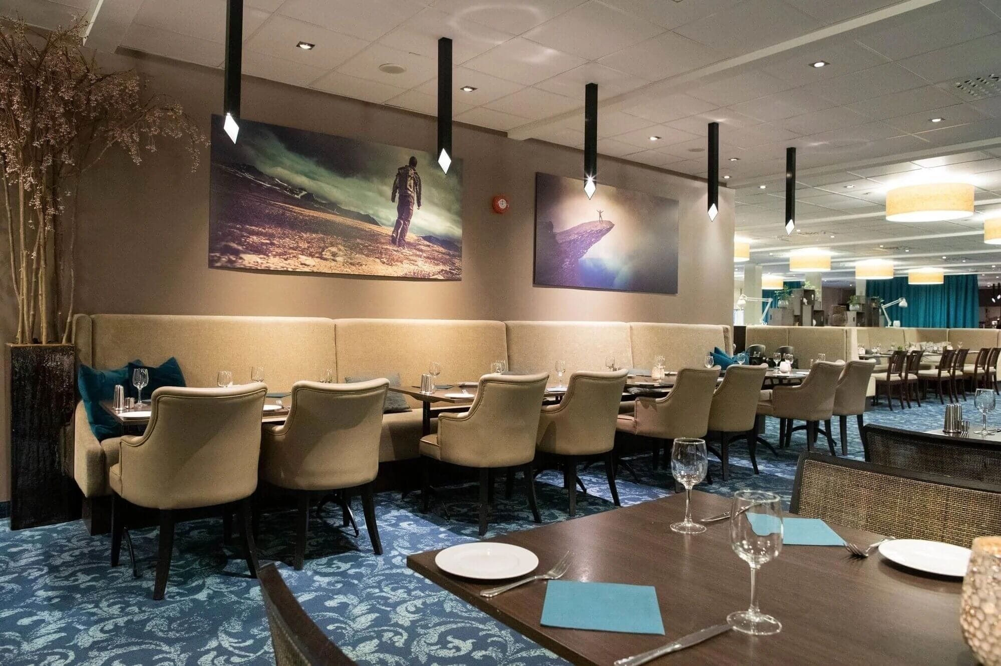 A restaurant with a long counter, booths, and high ceilings.