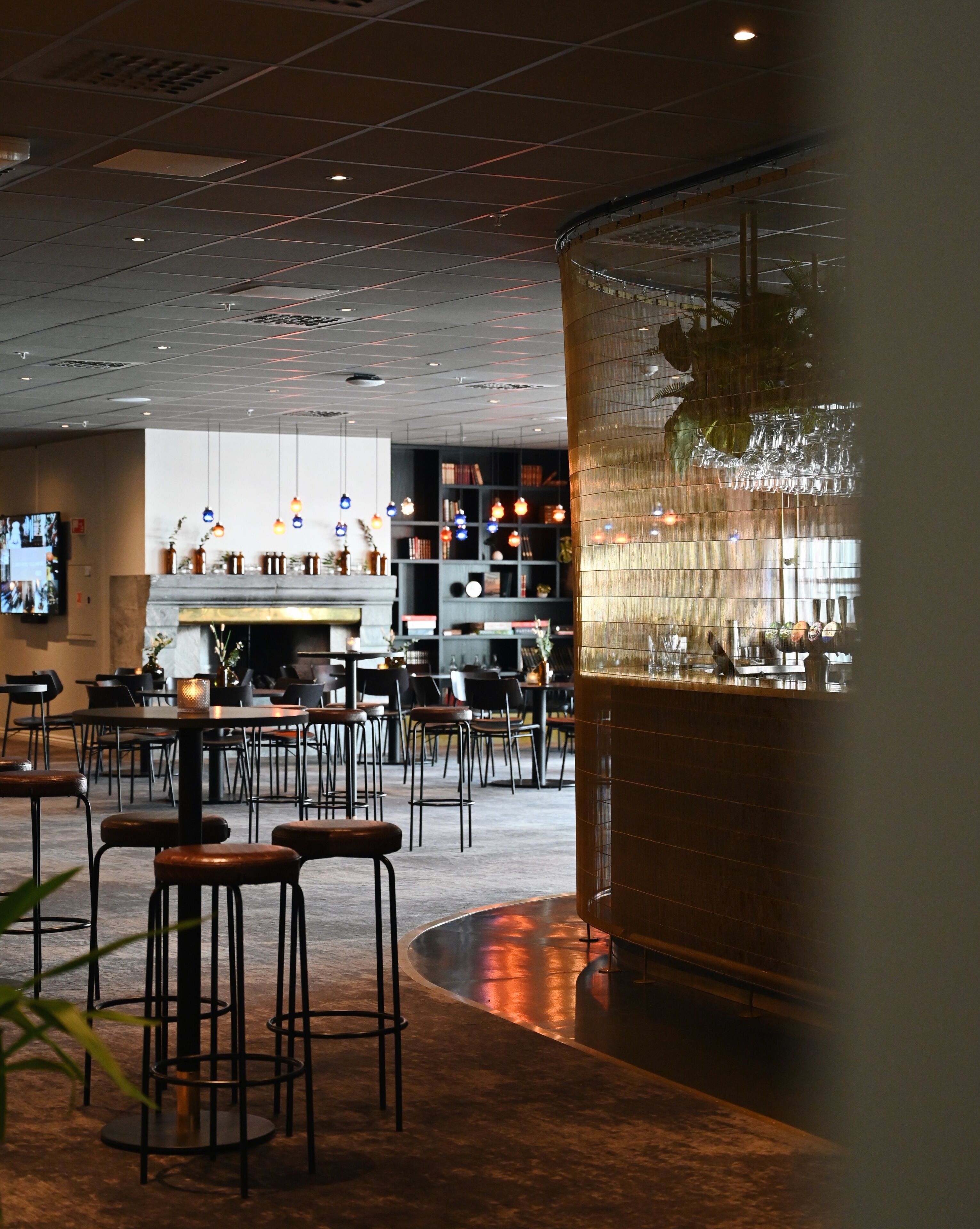 A modern interior with a bar area, seating, and a fireplace.
