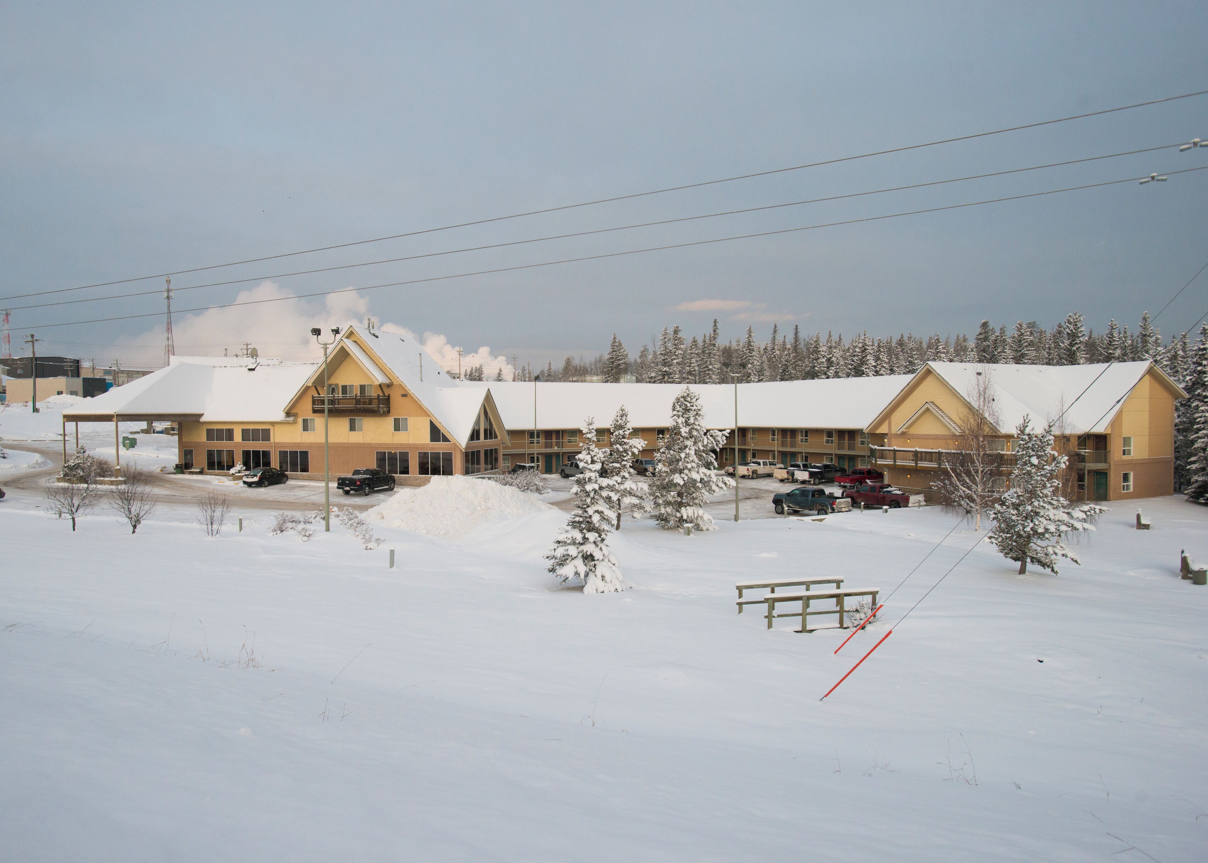 A hotel with multiple buildings, a parking lot, and snow-covered surroundings.