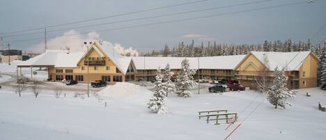 A hotel with multiple buildings, a parking lot, and snow-covered surroundings.