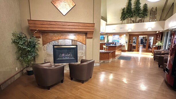 A spacious lobby with a fireplace, seating area, and a reception desk. - Lakeview Inns & Suites - Hinton (Hinton)