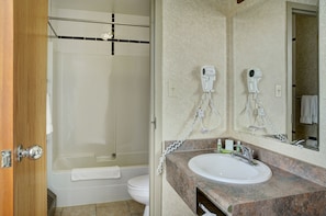A bathroom with a shower, toilet, and sink.