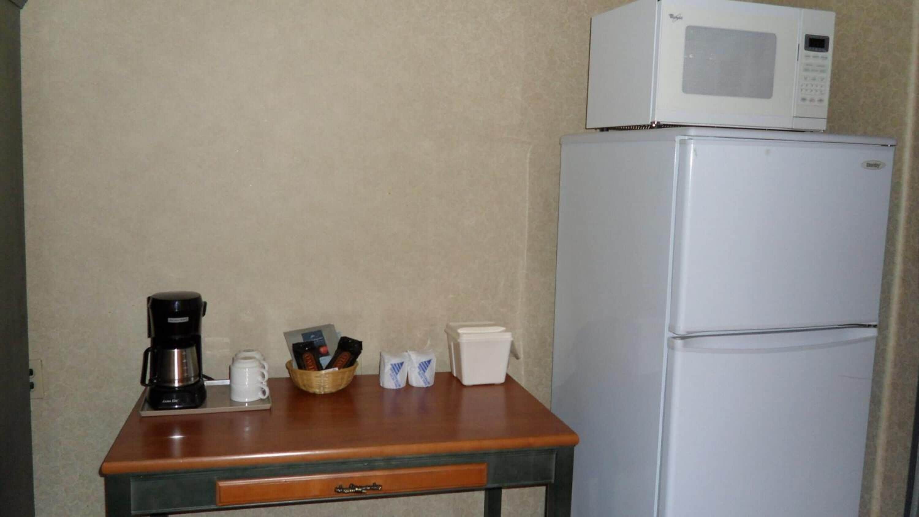 Una kitchenette equipada con microondas, cafetera y un refrigerador pequeño.