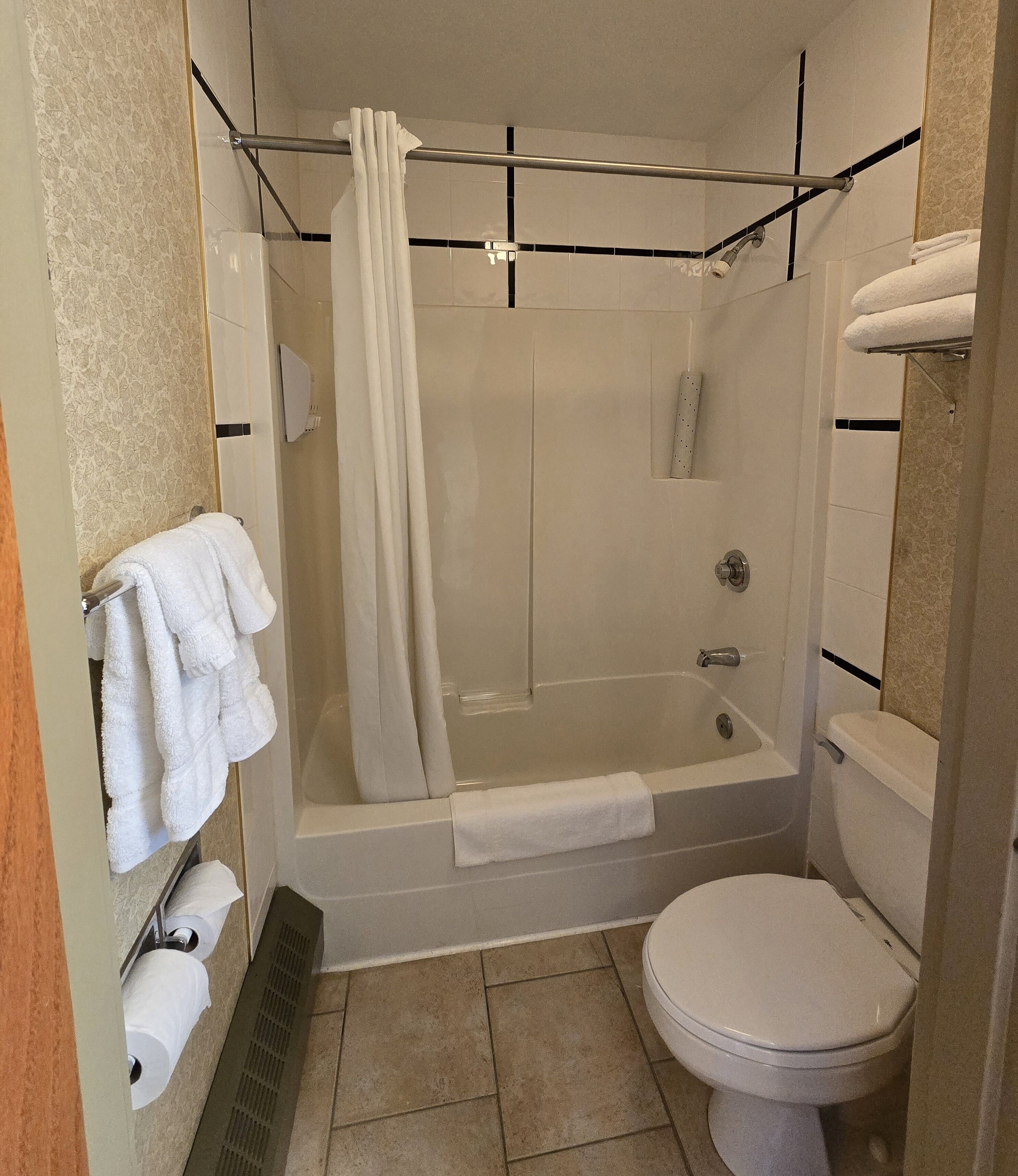 A bathroom with a bathtub, toilet, and towel rack.