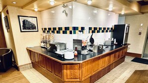 A kitchen area with a wooden counter, a waffle maker, a coffee machine, and a refrigerator. - Lakeview Inns & Suites - Hinton (Hinton)