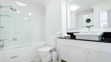A modern bathroom with a glass-enclosed shower, a white toilet, and a black countertop with a sink.