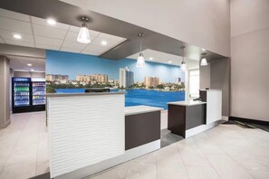 Un área de recepción con un mural de la ciudad, un refrigerador de Pepsi y una barra.