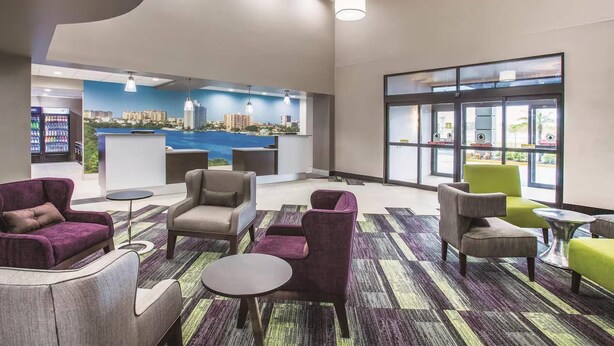 Un hall con asientos, un mostrador de recepción y un mural con vistas a la ciudad.