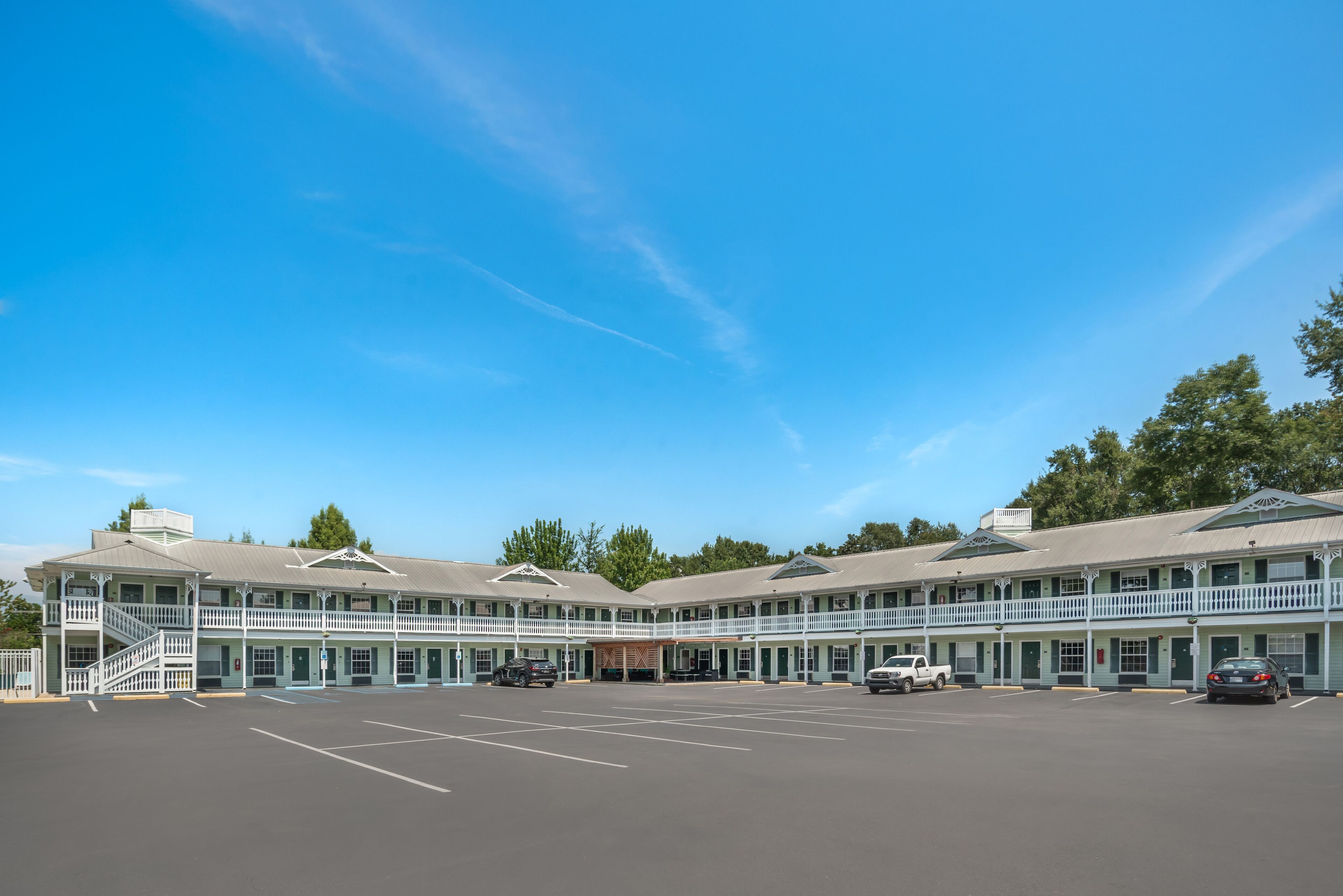 Un motel doté d’une cour intérieure, de plusieurs balcons et d’un parking.