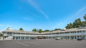 A motel with a central courtyard, multiple balconies, and a parking lot.
