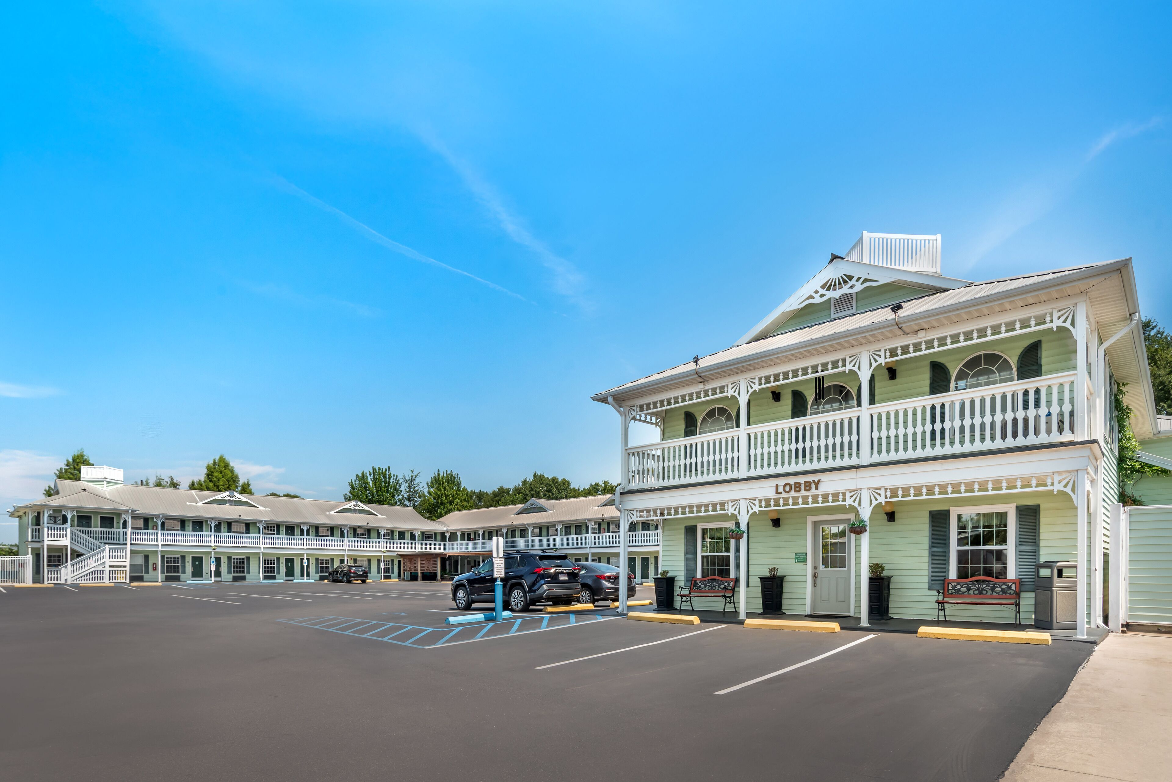 Een motel met een gebouw van twee verdiepingen, een balkon op de bovenverdieping en een bord met daarop 'LOBBY'.