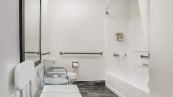 Une salle de bain équipée d’une douche accessible aux personnes en fauteuil roulant, de toilettes et d’un lavabo.