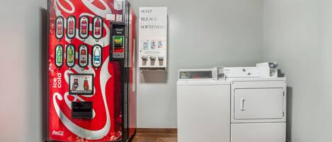 Máquina expendedora con diversas bebidas y un letrero anunciando jabón y lejía.