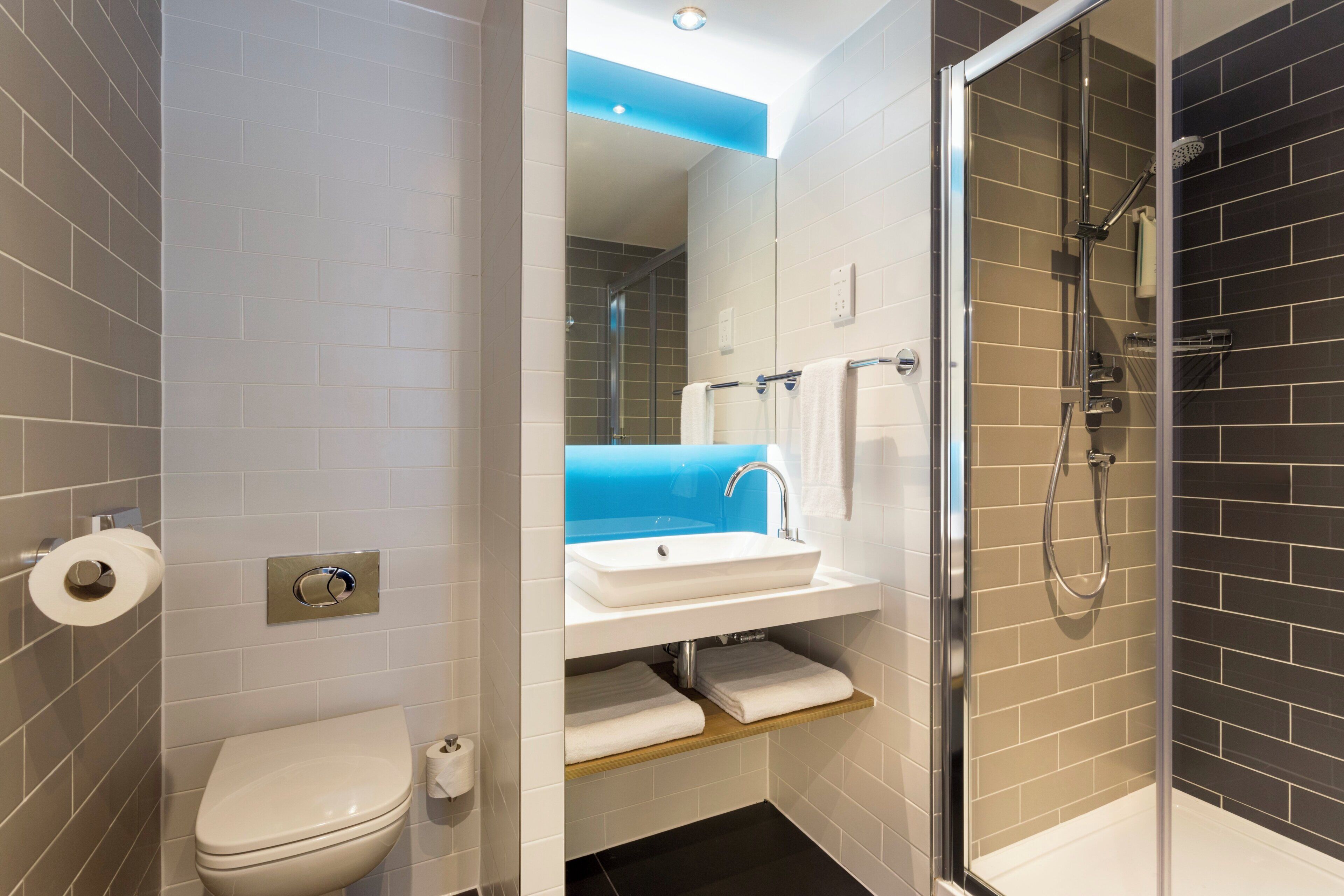 A modern bathroom with a toilet, sink, and shower.