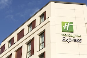 A Holiday Inn Express building with a modern design, featuring a prominent green logo and the name on the facade. - Holiday Inn Express London - Southwark by IHG (London)