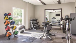 A gym with exercise equipment, a mirror, and a window. - La Quinta Inn & Suites by Wyndham Atlanta Perimeter Medical (Atlanta)