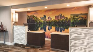 A reception area with a cityscape mural, two reception desks, and a wooden floor. - La Quinta Inn & Suites by Wyndham Atlanta Perimeter Medical (Atlanta)