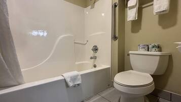 A bathroom with a bathtub, toilet, and a towel rack.