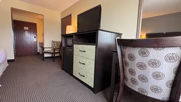 Habitación de hotel con escritorio, silla y televisor.