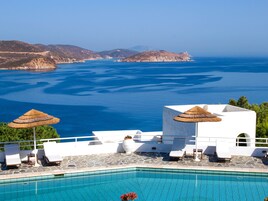 Una piscina al aire libre, sillones reclinables de piscina