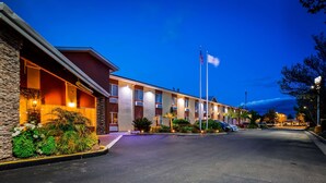 A motel with a stone facade, multiple rooms, and a flagpole. - Best Western Plus Corning Inn (Corning)