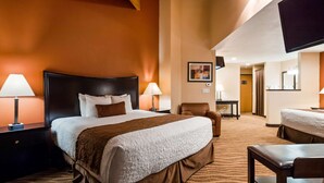 A hotel room with a large bed, two bedside tables with lamps, a chair, a desk, and a mirror. - Best Western Plus Corning Inn (Corning)