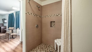 A shower area with a tiled floor, a small table, and a chair. - Motel 6 Rocky Mount, NC (Rocky Mount)
