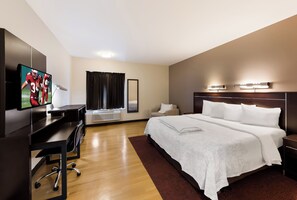 A hotel room with a bed, a desk, a TV, and a window with curtains. - Red Roof Inn PLUS+ Columbus Downtown-Convention Center (Columbus)