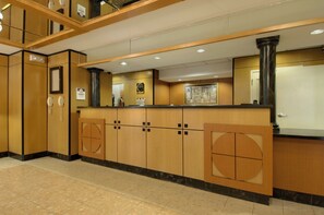 A reception area with a reception desk, a clock, and a framed map on the wall.