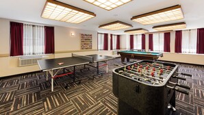 A room with a foosball table, ping pong table, and a pool table. - Red Roof Inn PLUS+ Columbus Downtown-Convention Center (Columbus)