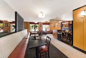 A restaurant with a long counter, booths, and a coffee machine. - Red Roof Inn PLUS+ Columbus Downtown-Convention Center (Columbus)