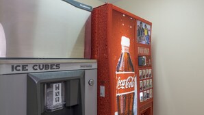 A vending machine with a Coca-Cola advertisement and an adjacent ice dispenser. - Red Roof Inn PLUS+ Columbus Downtown-Convention Center (Columbus)