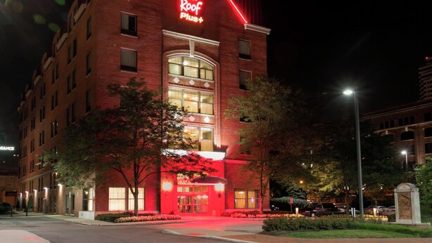 A Red Roof Plus hotel with a prominent red neon sign, large windows, and a well-lit entrance. - Red Roof Inn PLUS+ Columbus Downtown-Convention Center (Columbus)